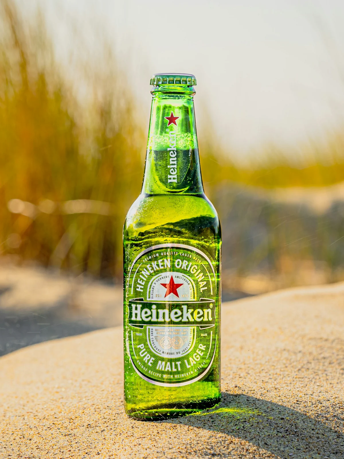 Garrafa de Heineken gelada na areia da praia